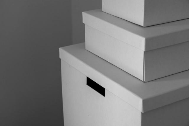 Réserve organisée pour locations saisonnières Espace de stockage pour conciergerie Airbnb avec cartons étiquetés et linge rangé sur des étagères